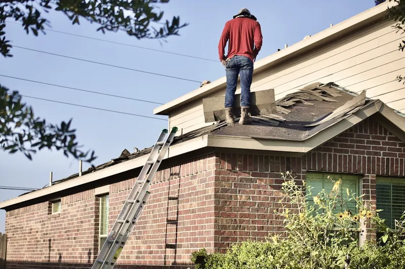 Professional roofer working on a residential roof in Quaker Farms